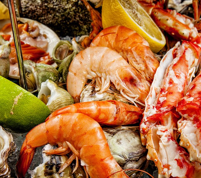 colorful pile of cooked seafood, shrimp, citrus and more