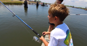 two young boys fishing off a dock
