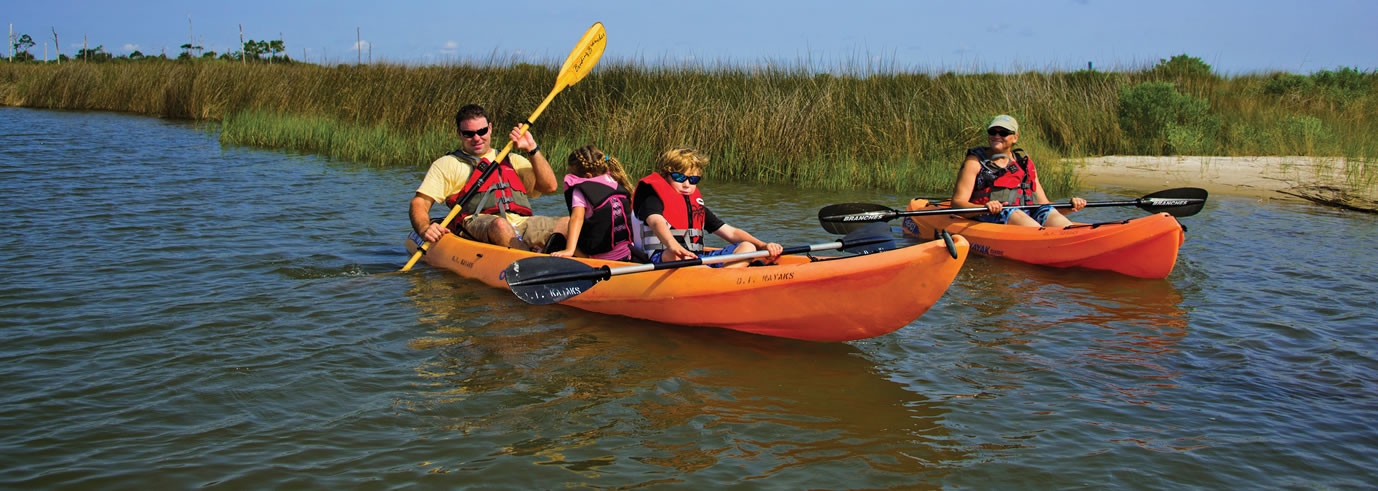 Kayakers in the bayou in orange kayaks